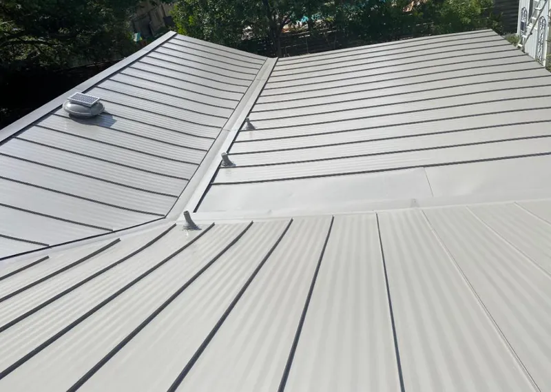 Solar attic fan installed on a metal roof for Roof Ventilation in Iowa Colony