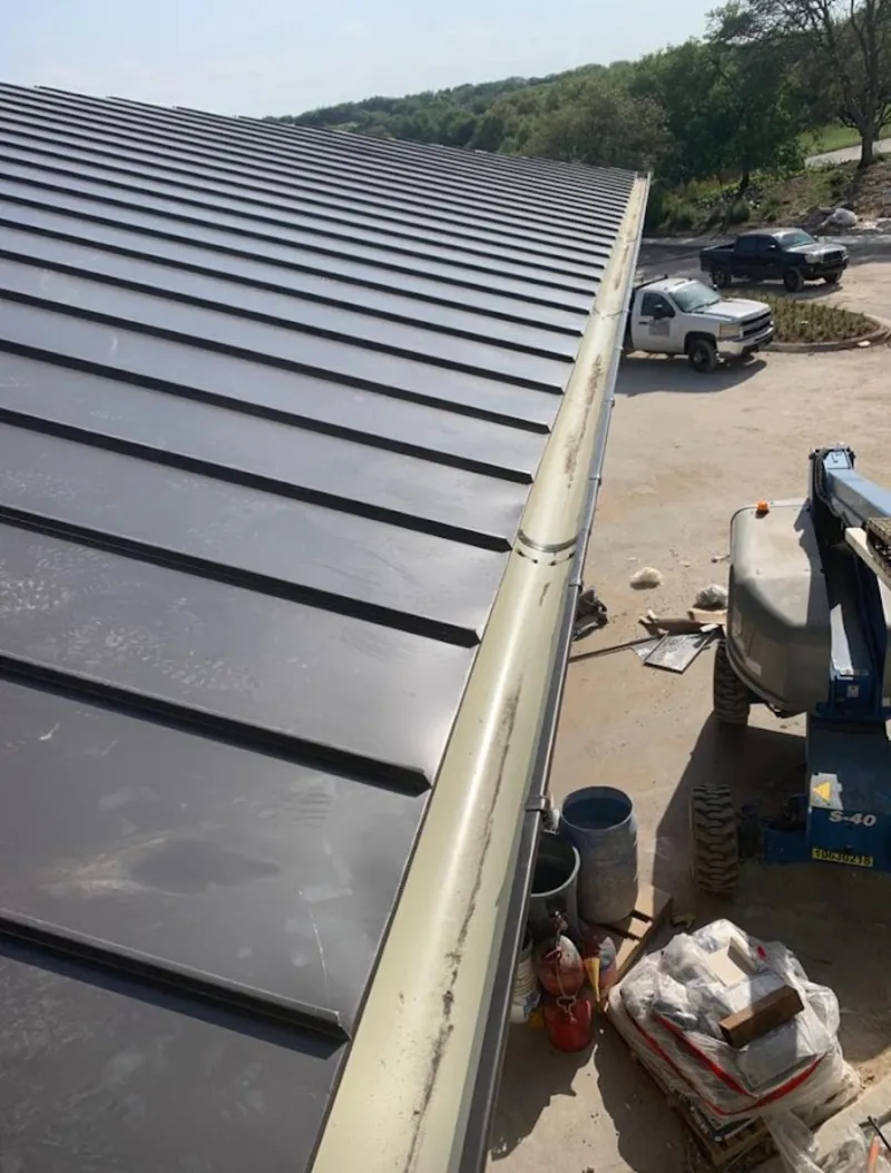 Standing seam panel and gutter detail on a metal roofing jobsite in Iowa Colony